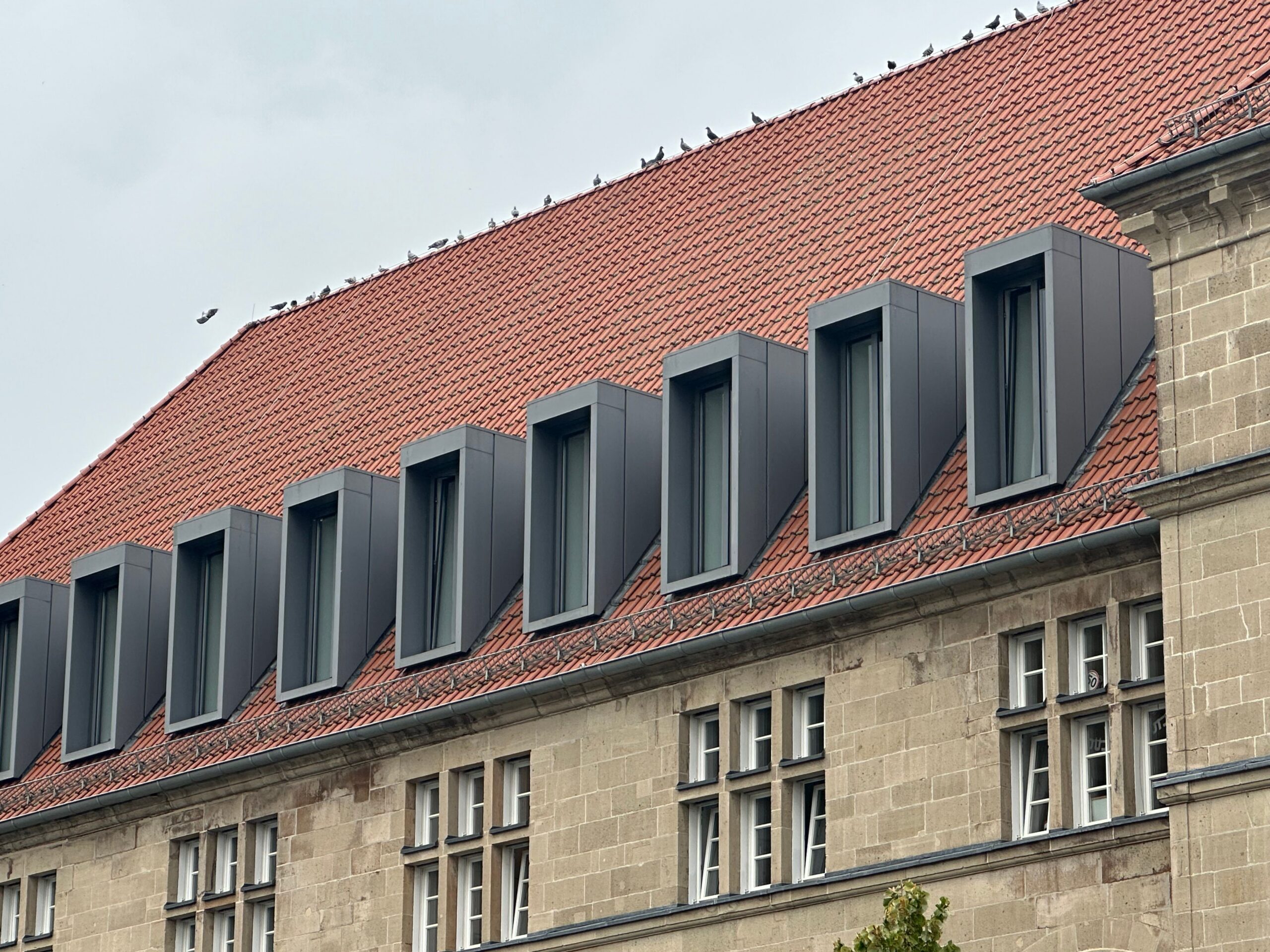 Modern design meets classic with red tiles and sleek windows.